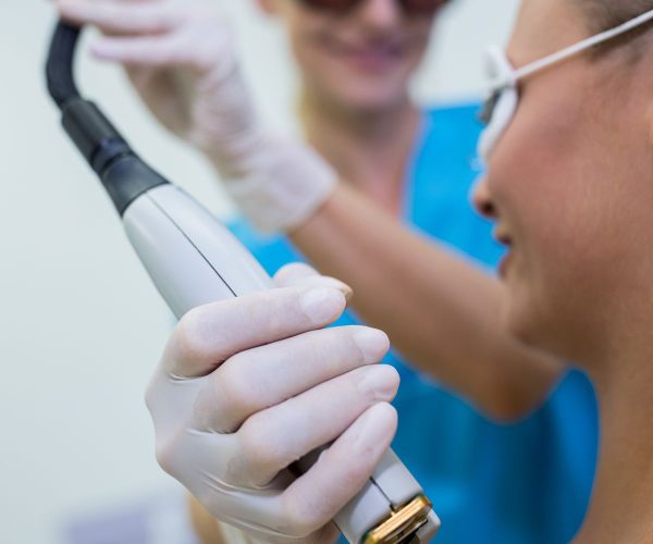 Woman receiving laser epilation treatment on her shoulder at beauty salon