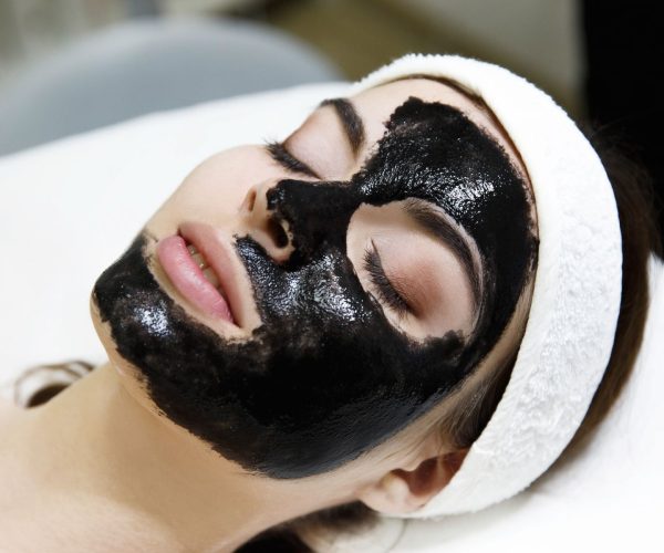 Girl with black mask lies on the table  in spa saloon